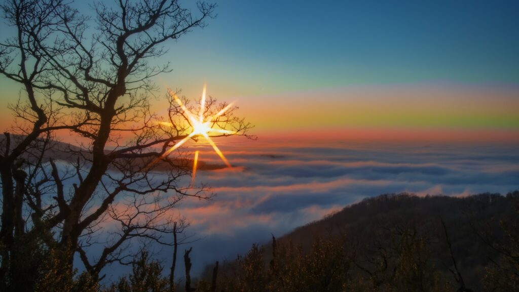 the sun is shining above the clouds in the sky